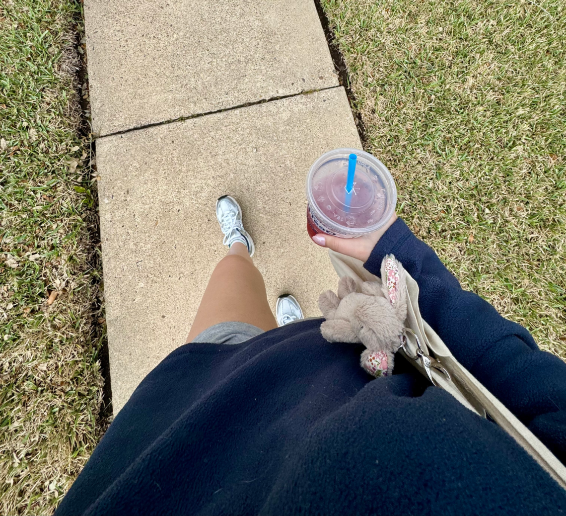 Walking with to go cup of tea with tote bag