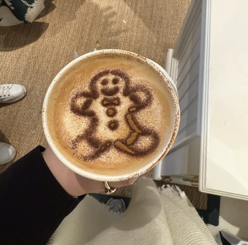 Latte with a gingerbread man dusted with cinnamon on top.